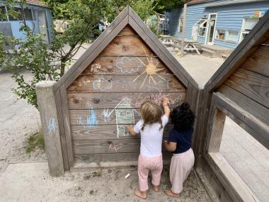 Børn der tegner med kridt på hus